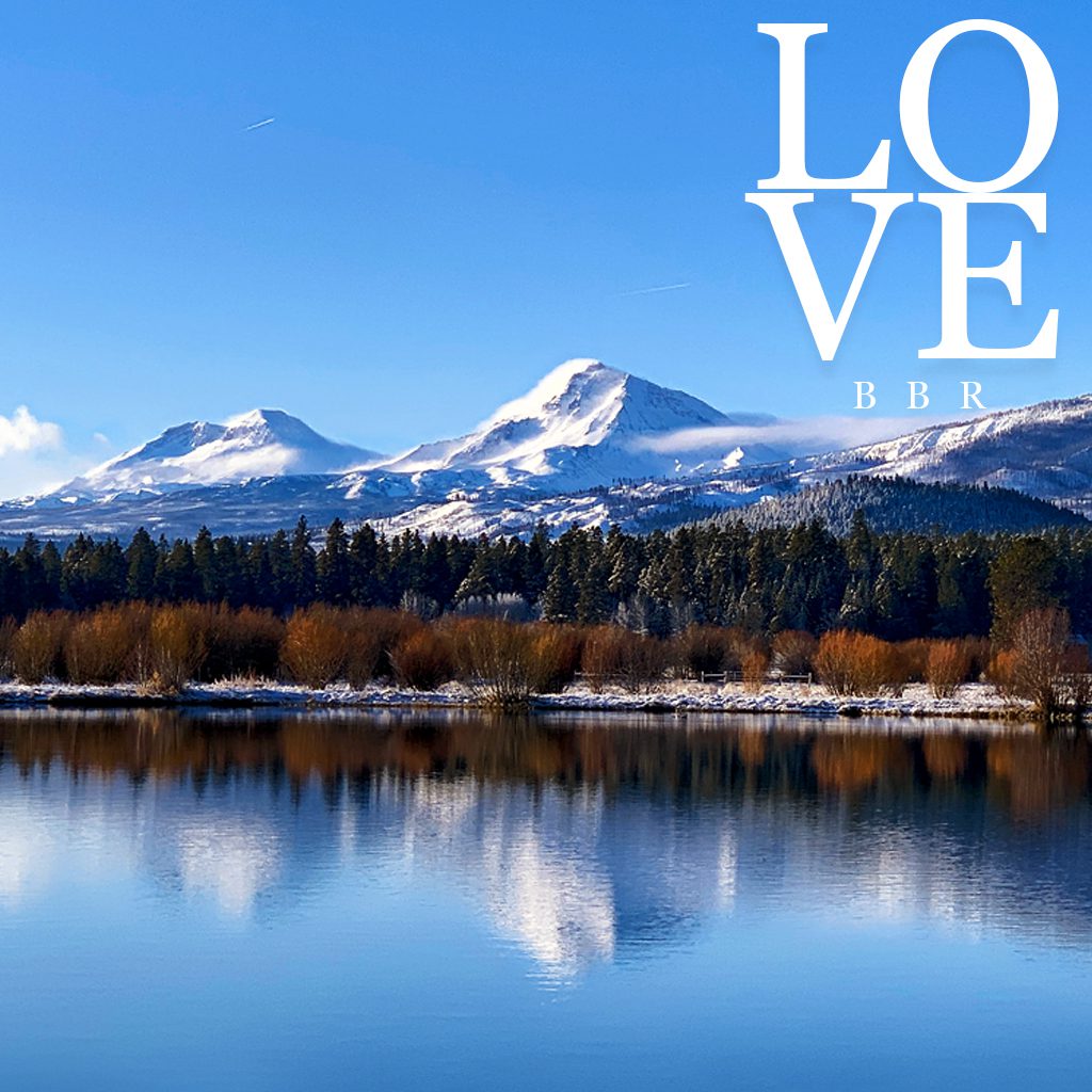 river reflecting black butte mountains. Text: Love BBR.