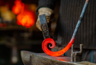 A blacksmith working on a piece you can find shopping in Sisters, Oregon.